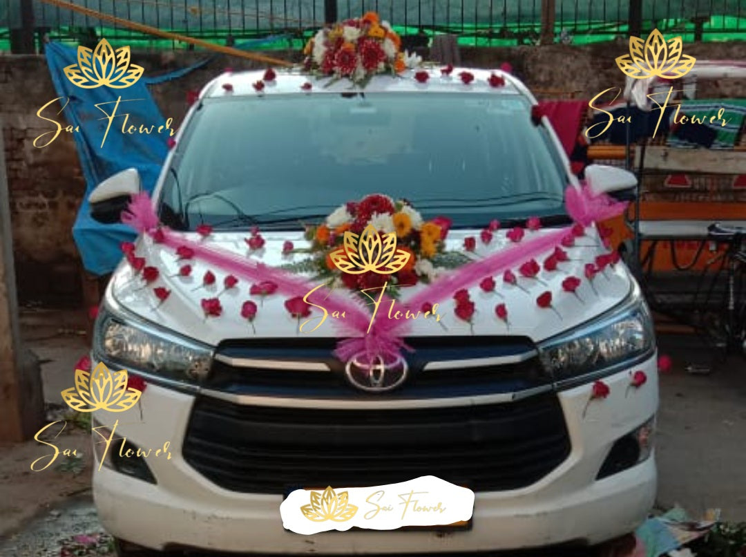 “Traditional wedding car decoration with red roses, gerberas, and pink ribbons by Sai Flower Delhi NCR.”
