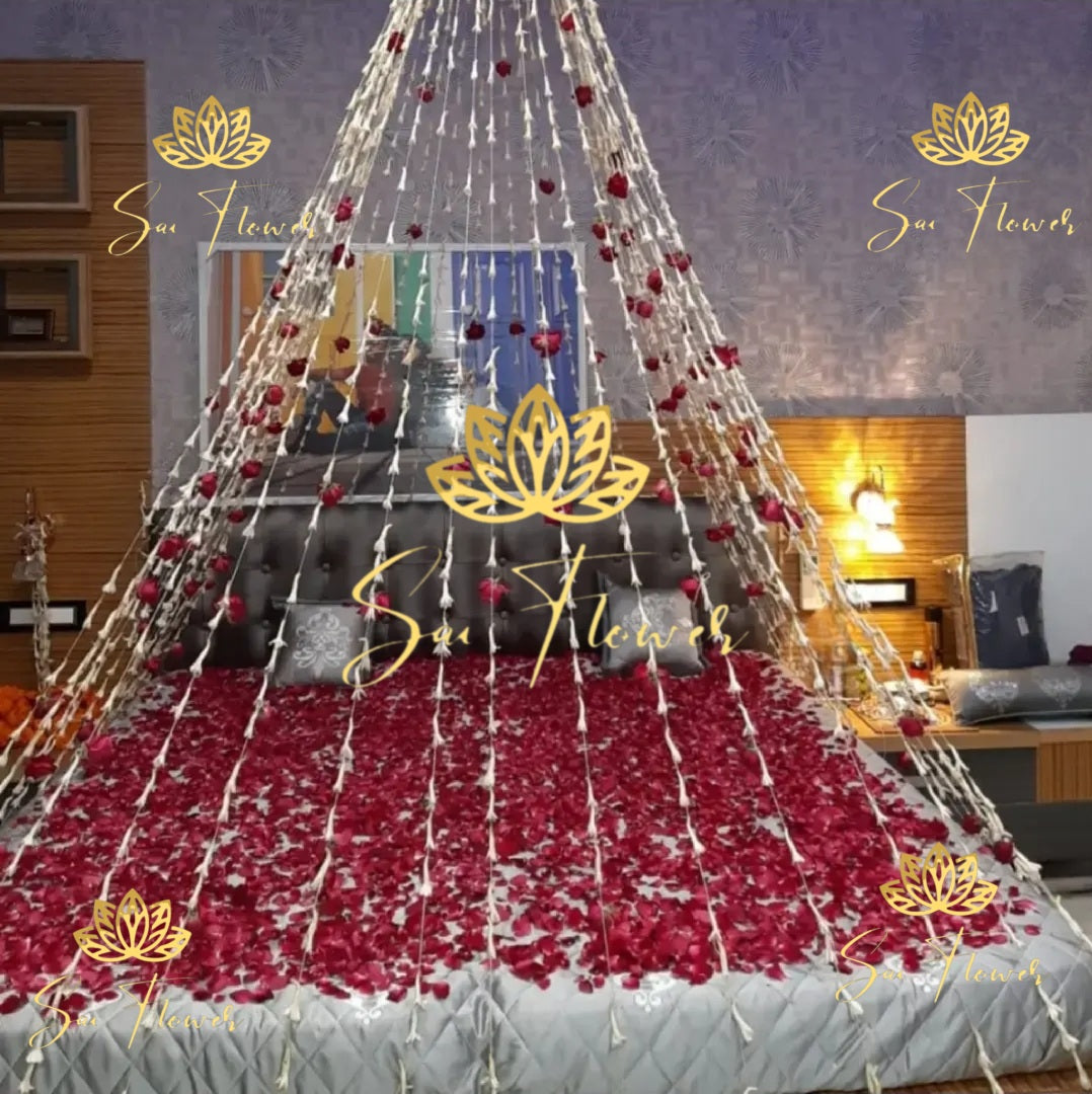 “Traditional jasmine and red rose cone-style bed decoration with rose petals and hanging flower garlands by SaiFlower”