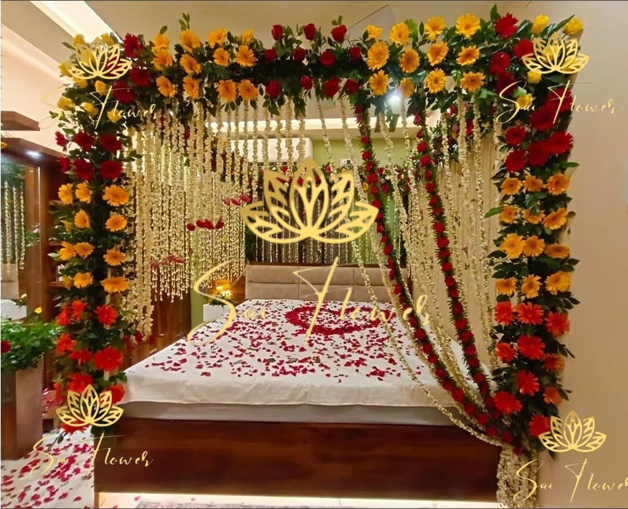 “Luxury canopy-style bed decoration with red roses, yellow gerberas, and jasmine strings by SaiFlower for wedding and anniversary occasions”